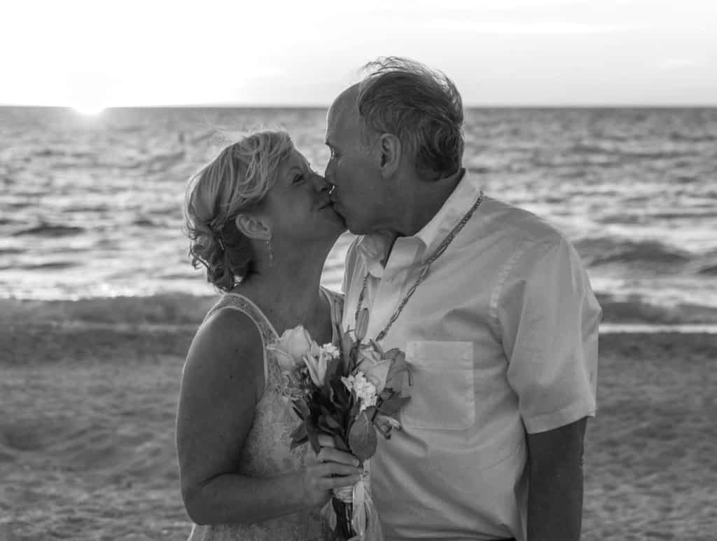 Older couple kissing on the beach_monogamy