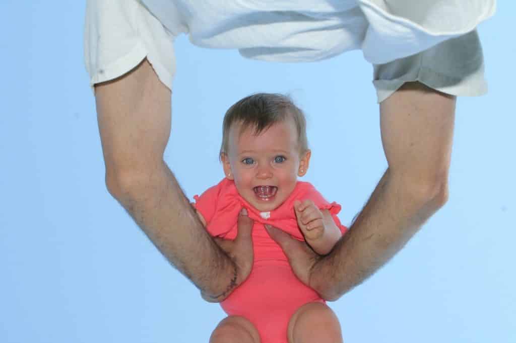 Baby Girl filled with Laughter as her father holds her